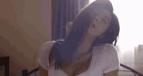 a woman is laying on a bed with her eyes closed .
