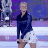 a woman is dancing on a stage with a microphone .
