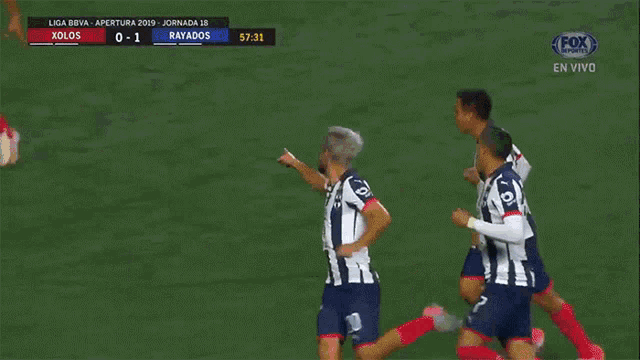 three soccer players are celebrating a goal in front of a banner that says bardahl