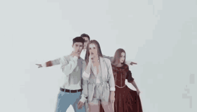 a group of people are standing next to each other and one of them is covering her mouth .