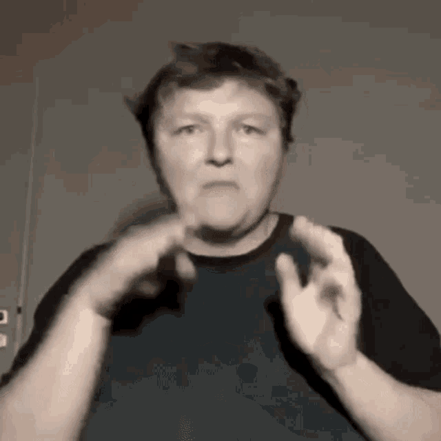 a woman is making a funny face with her hands .