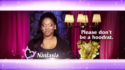 a woman named nastasia is standing in front of a purple curtain .
