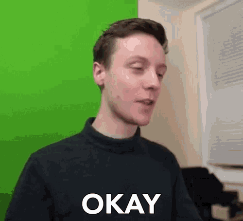 a man in a black shirt with the word okay on it