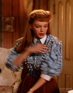 a woman in a blue shirt and brown skirt is dancing