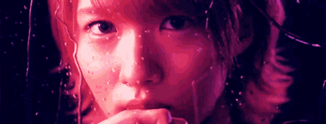 a close up of a woman 's face with a purple background