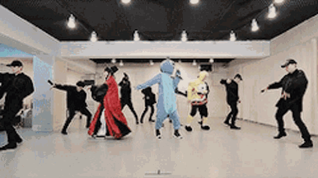 a group of people in costumes are dancing in a dance studio .