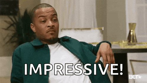 a man in a green jacket is sitting on a couch and says impressive !