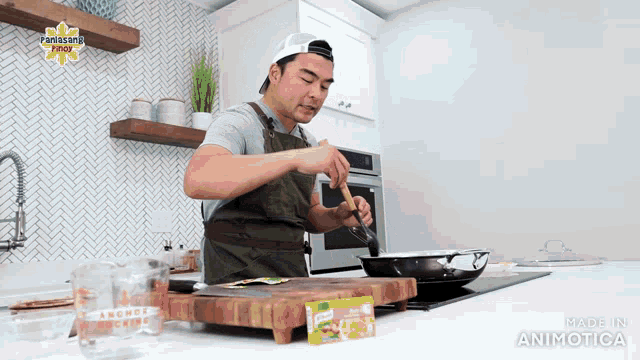 a man in an apron is cooking in a kitchen with a panasonic logo on the wall above him