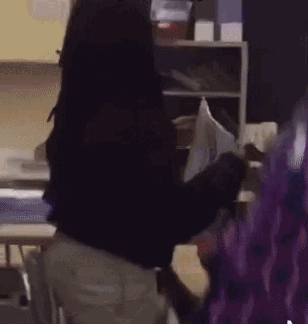 a person is standing in a classroom with a red tray on the desk