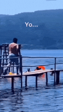 a man is standing on a dock overlooking a body of water with the words yo written on the bottom