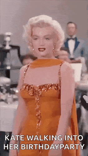 a woman in an orange dress is walking into her birthday party .