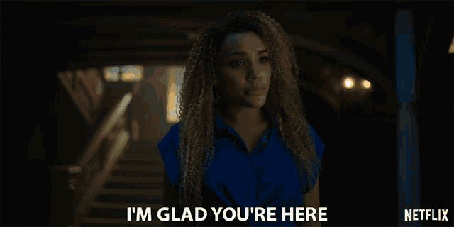 a woman in a blue shirt says " i 'm glad you 're here " in a netflix ad