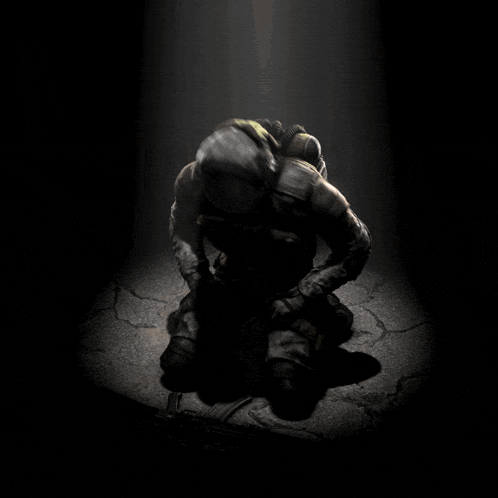 a soldier is kneeling down in the dark