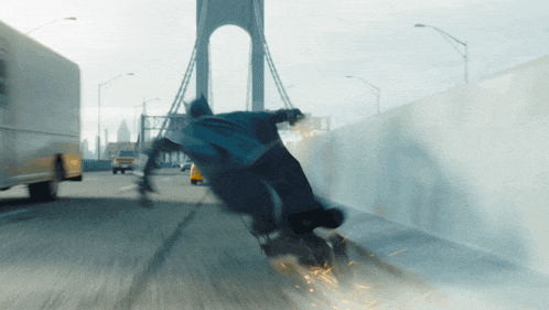 a blurry picture of a person riding a motorcycle on a street with a bridge in the background