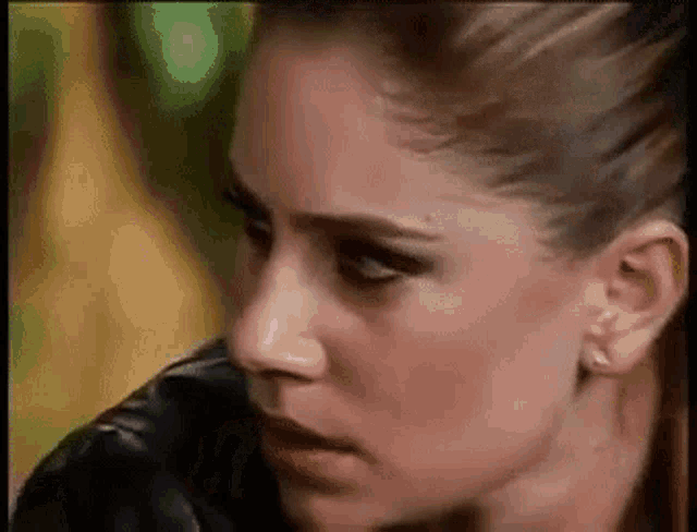 a close up of a woman 's face with a serious expression .