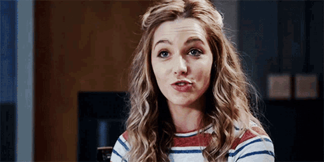 a woman with a striped shirt on making a funny face
