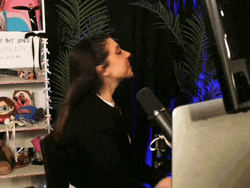 a woman is singing into a microphone in front of a sign that says i am not done