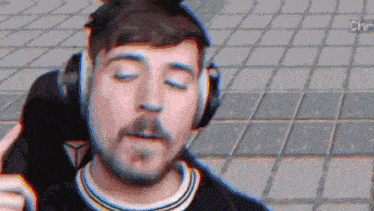 a man with a beard wearing headphones is standing on a tiled floor .