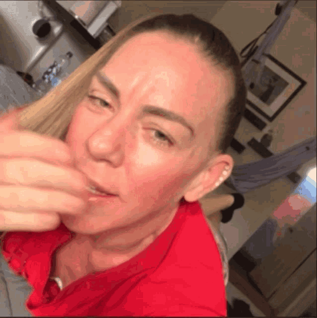 a woman in a red shirt is looking at something
