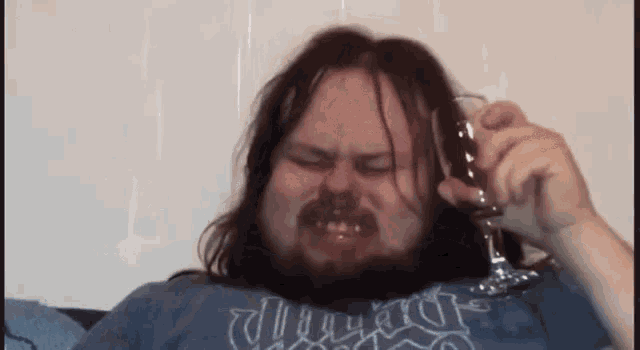 a man with a beard is holding a wine glass and wearing a shirt that says chicago