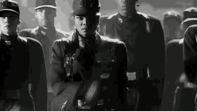 a black and white photo of a woman in a military uniform with the letter s on her hat