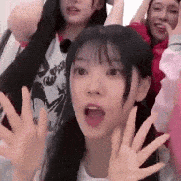 a group of young girls are standing next to each other with their hands outstretched .