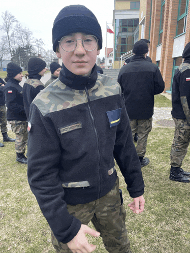 a boy in a military uniform has a patch on his jacket that says szymon