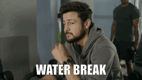 a man with a beard is sitting in a gym with the words water break written on the bottom