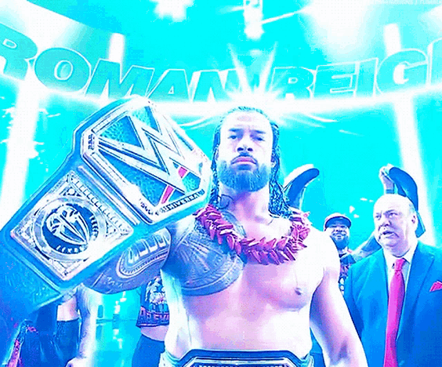 roman reigns is holding a wrestling championship belt