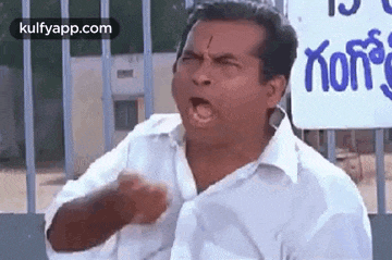 a man in a white shirt is making a funny face with his mouth open .