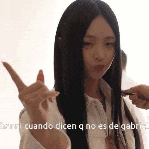 a woman with long black hair is being brushed by a man with the words hanni cuando dicen q no es de gabriel below her