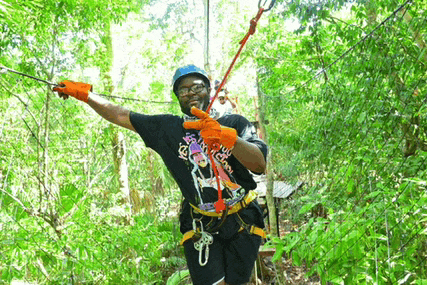 a man wearing a shirt that says ' i love you ' on it is hanging from a rope in the woods