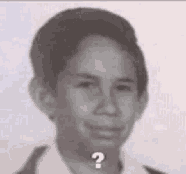 a black and white photo of a young boy with a question mark on his face .