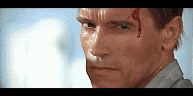 a close up of a man 's face with blood coming out of his forehead