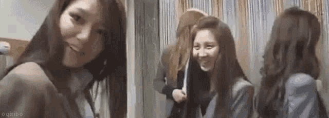 a group of girls are standing next to each other in a room .
