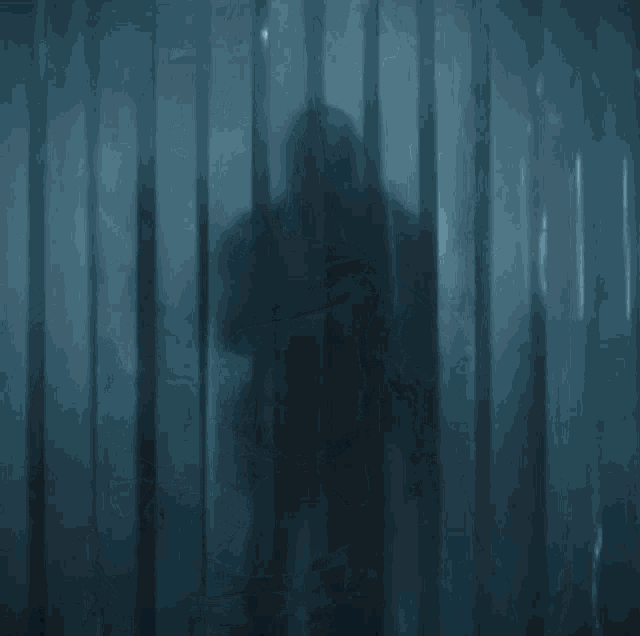 a man in armor is standing in a dark room