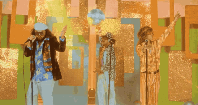 a group of people singing in front of a disco ball