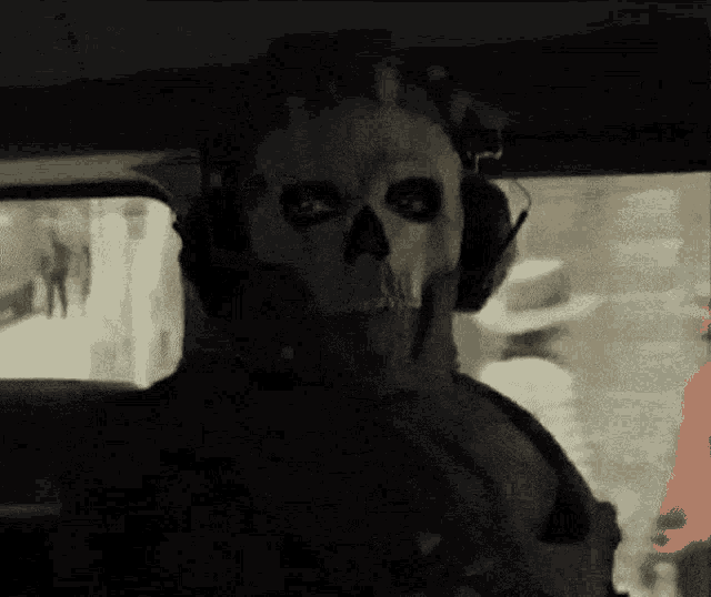 a man wearing a skull mask is sitting in a car
