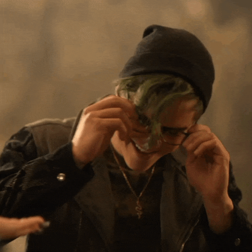 a man with green hair wearing a black beanie and glasses