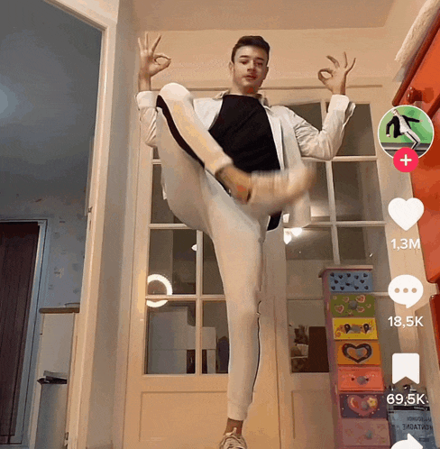 a man in a white suit is doing a split in front of a door that has a 1.3m sign on it