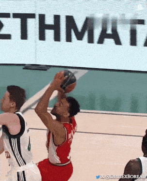 a basketball game is being played in front of a sign that says " ethmata "
