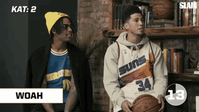 two basketball players wearing suns jerseys sit next to each other