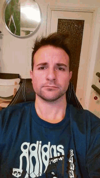 a man wearing a blue shirt that says adidas on the front
