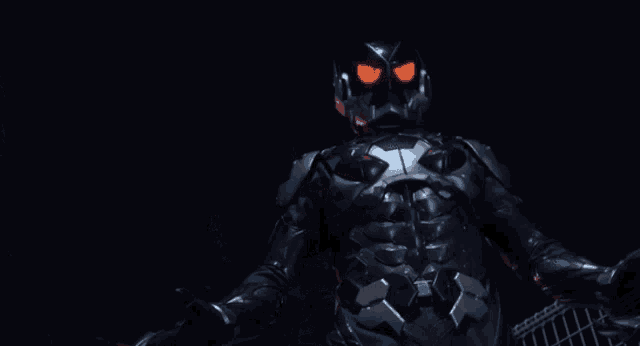a man in a black suit with red eyes stands in the dark