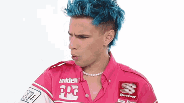 a man with blue hair and a pink shirt that says speedway on it