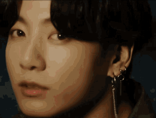 a close up of a person 's face with earrings on it