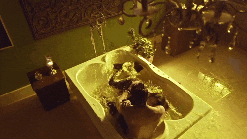 a man and a woman are laying in a bathtub filled with water