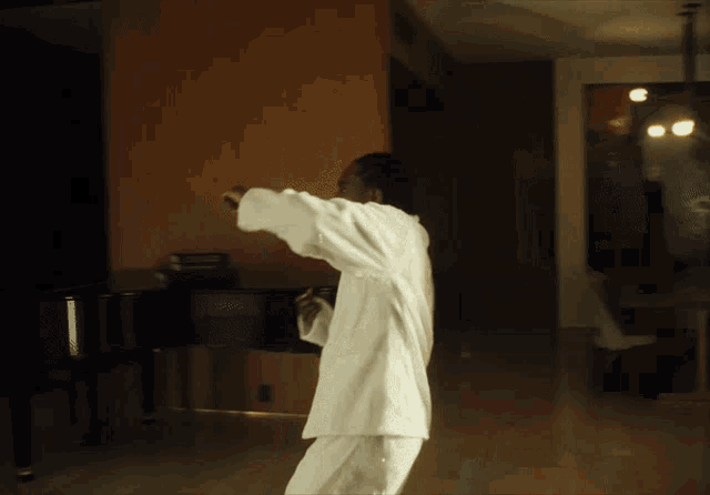 a man in a white shirt is standing in front of a black piano