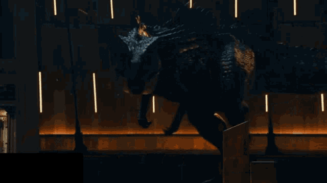 a dinosaur is standing in a dark room with lights on the wall