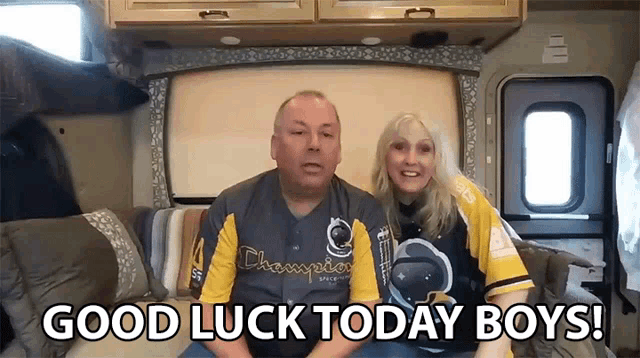 a man and a woman are sitting in a rv and they are saying good luck today boys